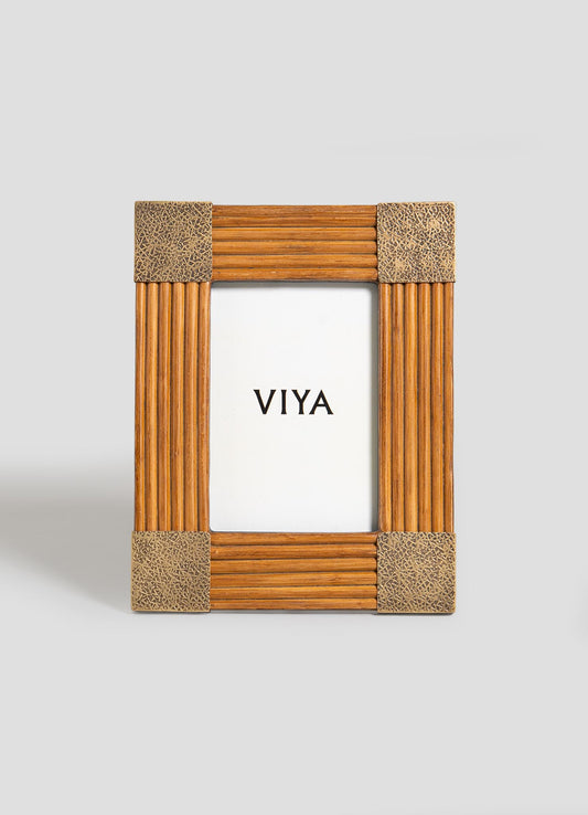 The Namsai Photo Frame Small by VIYA is a vertical, rectangular wooden frame with textured gold corners and brass accents. Shown on a light gray background, it features a white insert displaying "VIYA" in bold black letters.