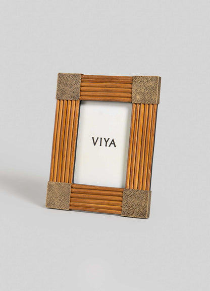 The VIYA Namsai Photo Frame Small stands upright with textured brown corners and brass accents, showcasing a white insert with "VIYA" in bold black at the center. The background is light gray.