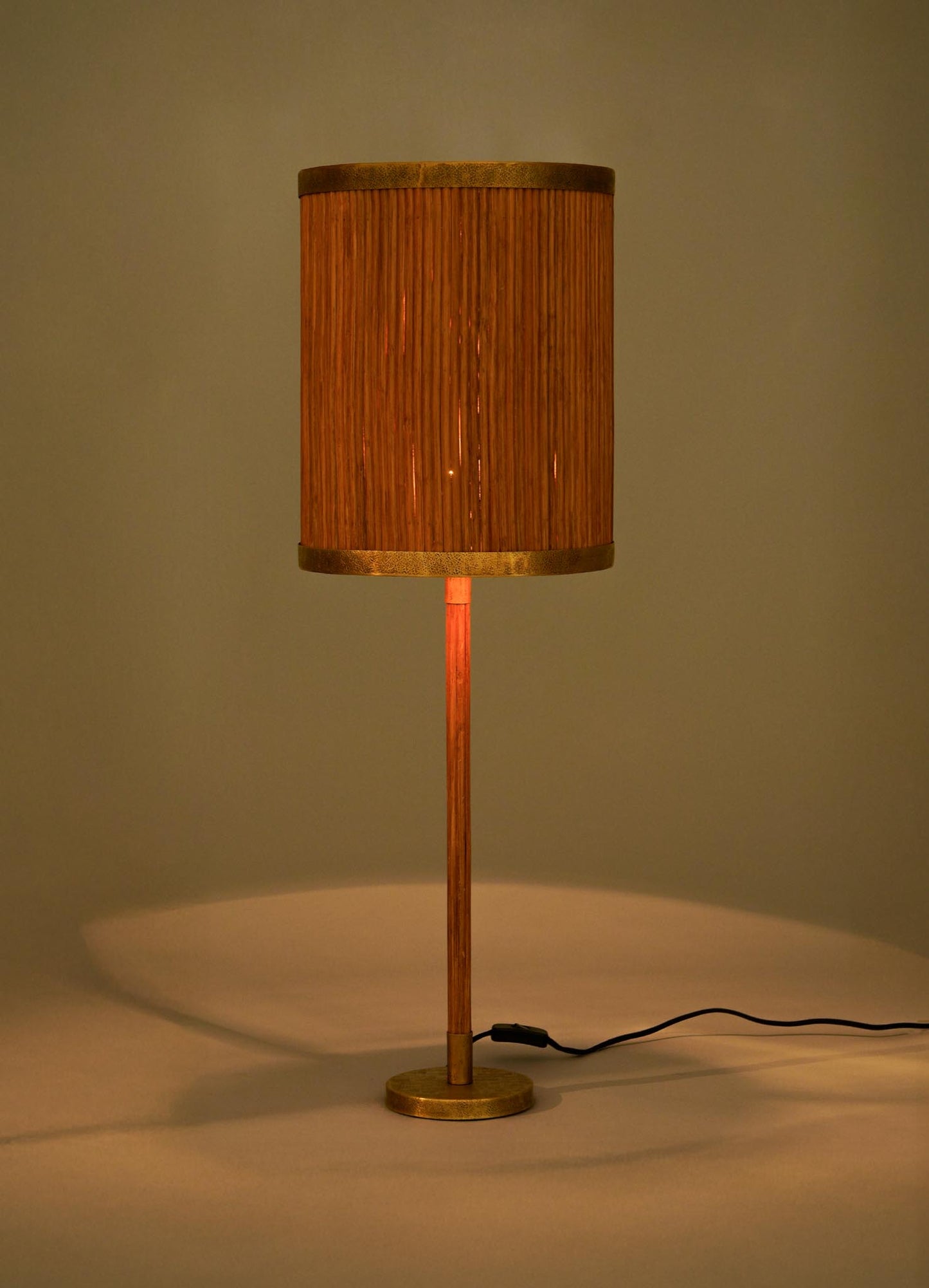 The VIYA Namsai Table Lamp Tall features a cylindrical design with a wooden base, brass accents, and a ribbed vertical-patterned shade that emits warm, soft light. A visible black power cord completes its elegant look.