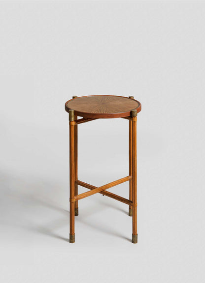 The VIYA Namsai Tray Table Large features a round top with a sunburst pattern, four slender legs, brass accents, and crossed support bars, shown against a plain light gray background.