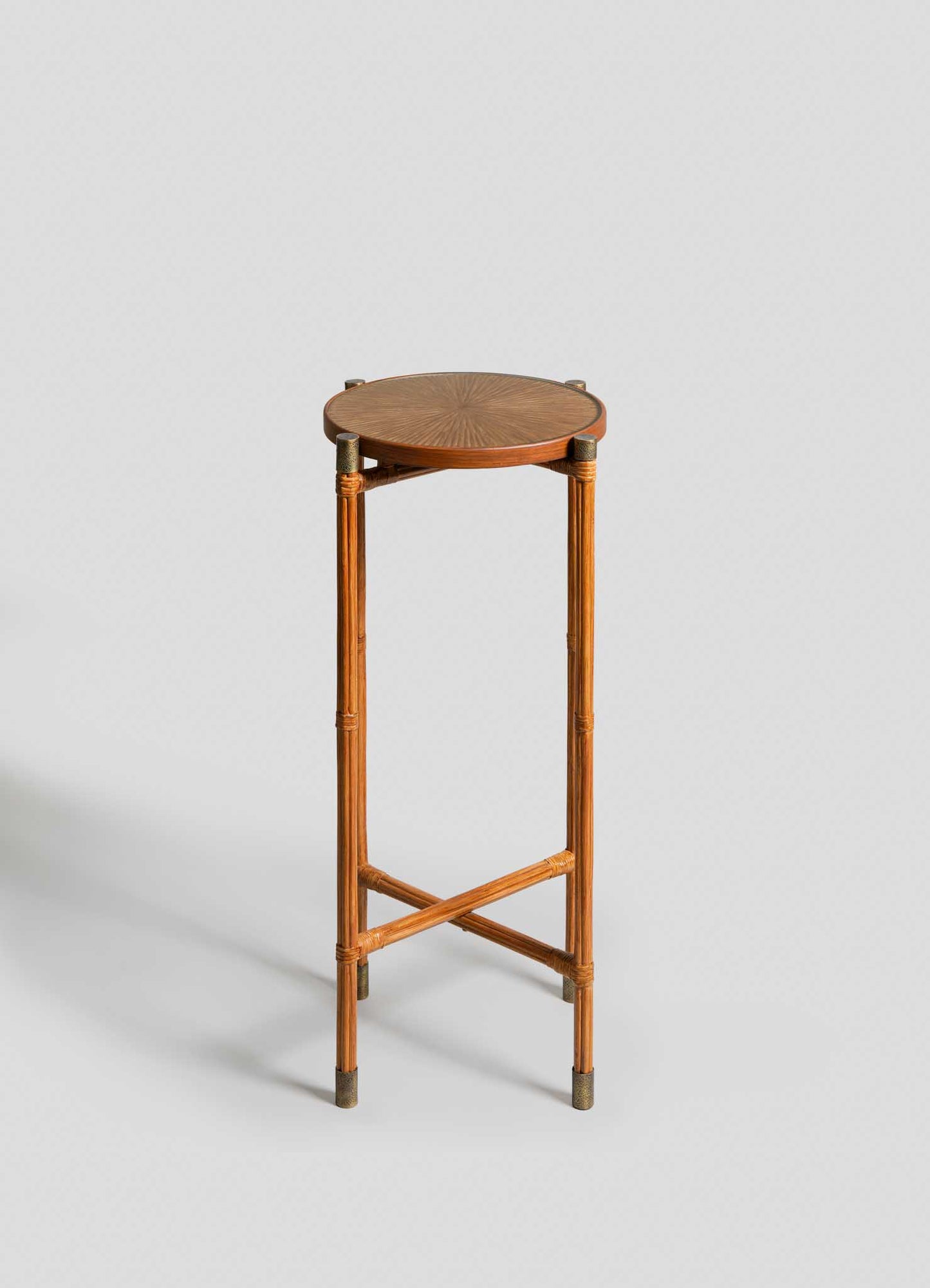 The VIYA Namsai Tray Table Tall features a round wooden frame, slim legs with crossed supports, and a finely patterned cane-weave top, showcased against a light gray background.