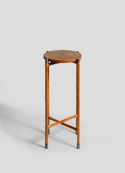 The VIYA Namsai Tray Table Tall features a round wooden frame, slim legs with crossed supports, and a finely patterned cane-weave top, showcased against a light gray background.