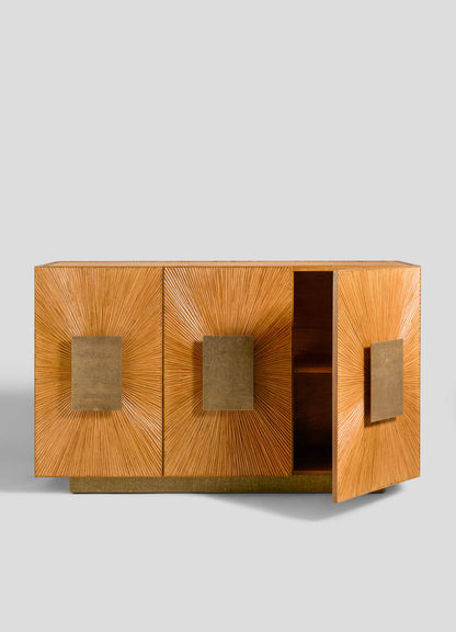 The VIYA Namsai Cabinet is a wooden sideboard with three sunburst-patterned doors and large square brass handles; one door stands slightly open to reveal the interior, set against a plain light gray background.