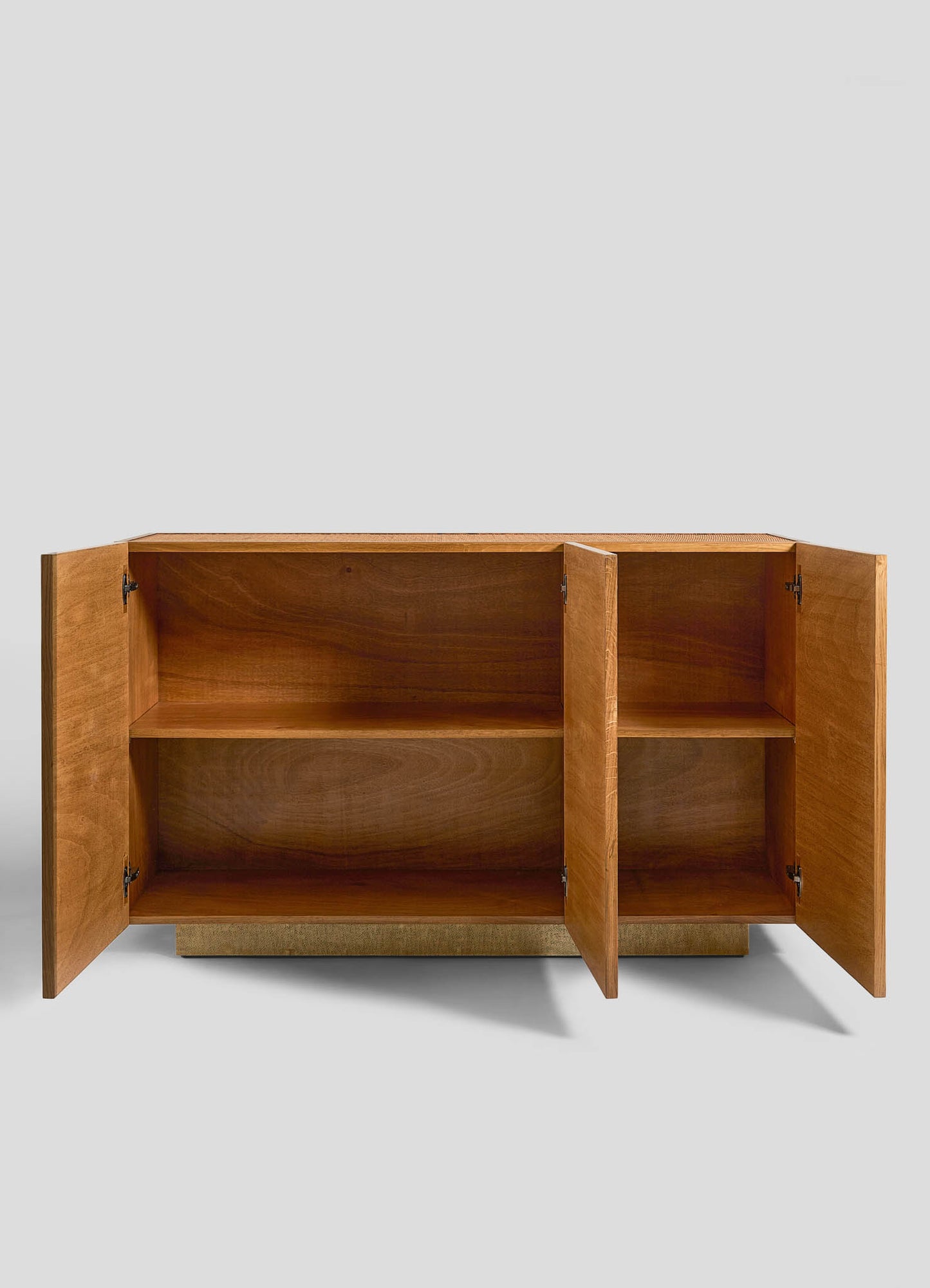 The VIYA Namsai Cabinet features a simple rectangular wooden design with brass handles, two open doors revealing an interior shelf, and rests on a short textured base against a plain gray background.