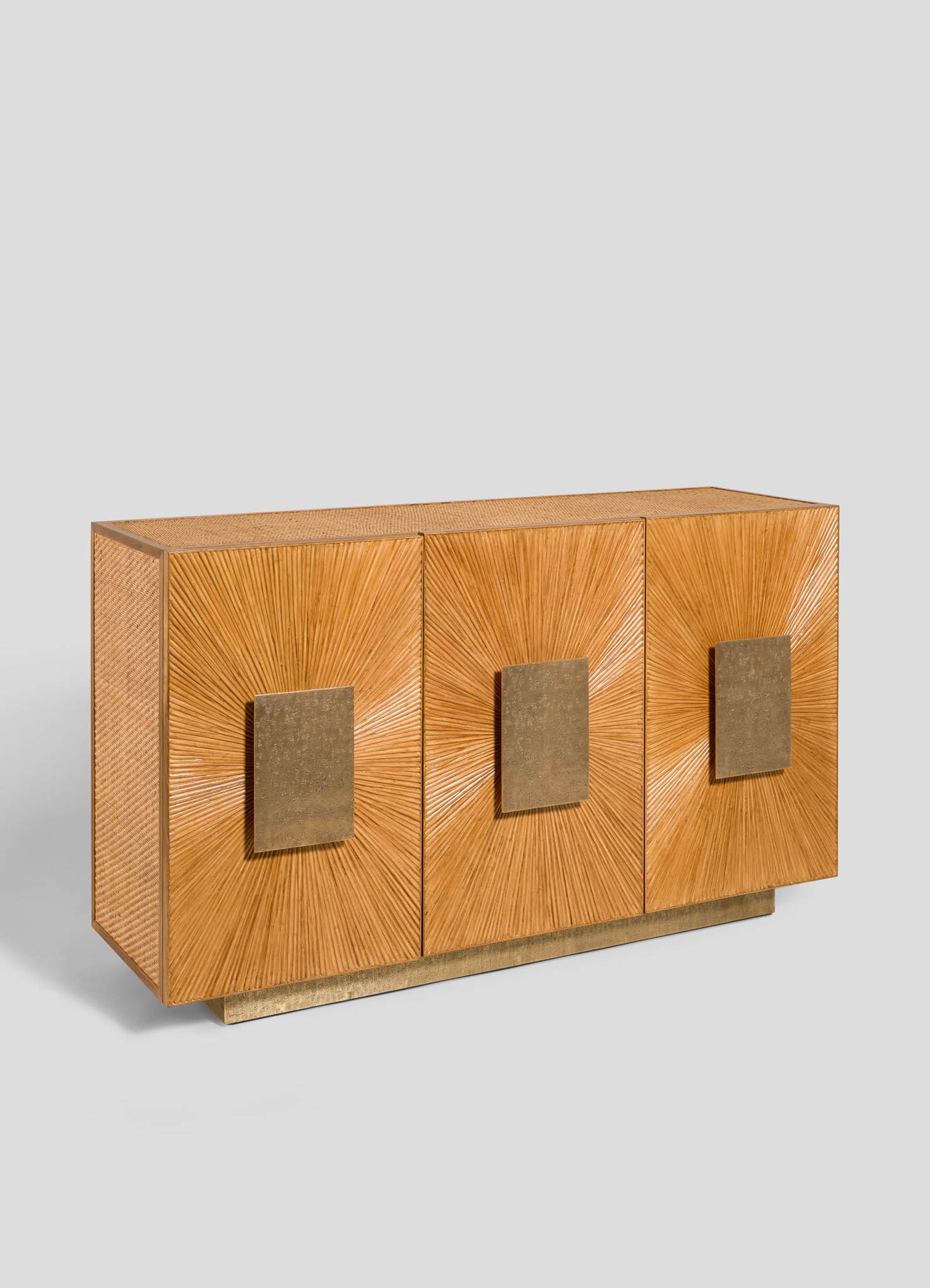 The VIYA Namsai Cabinet is a wooden sideboard with three sunburst-patterned doors, large square brass handles, a warm golden-brown finish, and stands on a simple rectangular base.