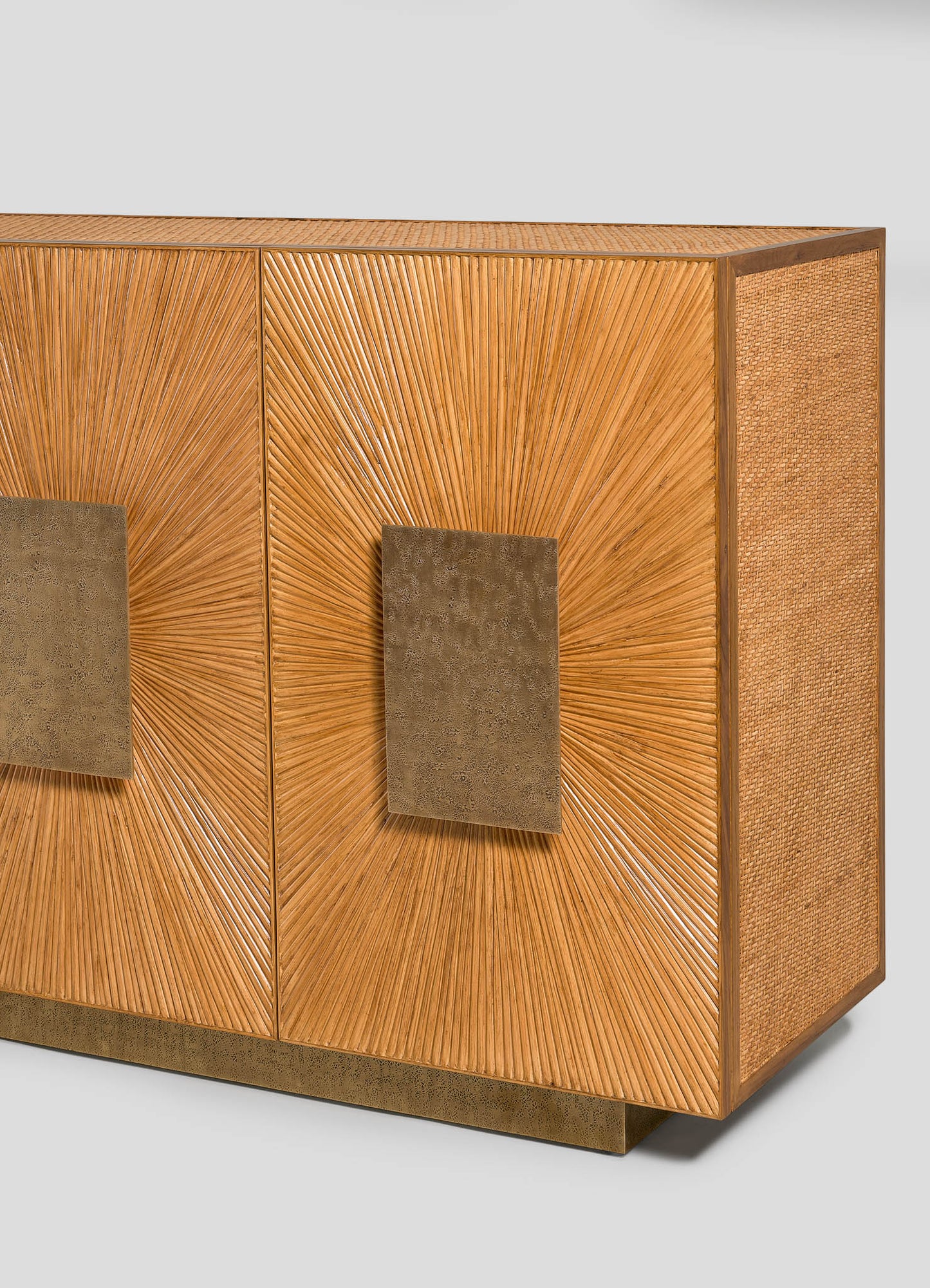 The VIYA Namsai Cabinet features two sunburst-patterned wooden doors with square brass handles, textured sides, and a bronze base, set against a plain light background—ideal for those seeking distinctive and refined cabinetry.