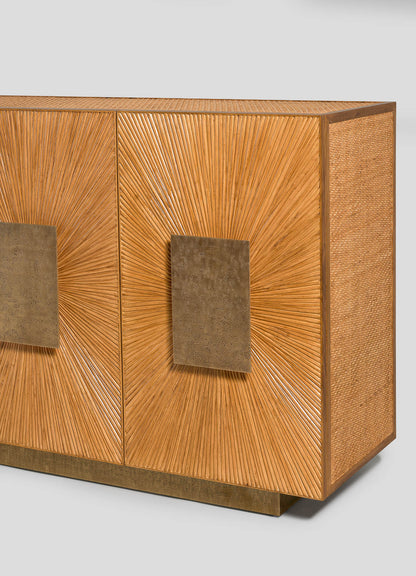 The VIYA Namsai Cabinet features two sunburst-patterned wooden doors with square brass handles, textured sides, and a bronze base, set against a plain light background—ideal for those seeking distinctive and refined cabinetry.