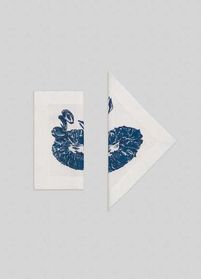 A set of four Orchard Blue Cocktail Napkins by Viya, featuring a blue mushroom print, arranged side by side on a light gray background—perfect for adding Indian fruit orchard-inspired charm to your table.