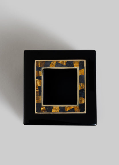 The VIYA Plaza Cube Tissue Box is a glossy black square with a gold and black Art Deco patterned lid, inspired by Bombay’s cinema halls, shown against a plain gray background.