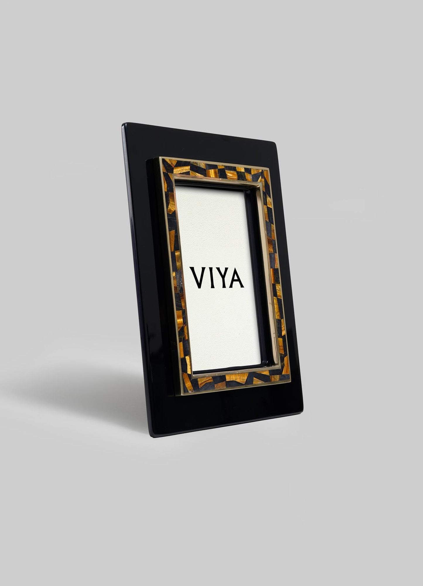 The Plaza Photo Frame by VIYA features a glossy black rectangular outer border and a tortoiseshell-patterned inner border, inspired by Bombay Art Deco cinema halls, with VIYA displayed on a plain white background.