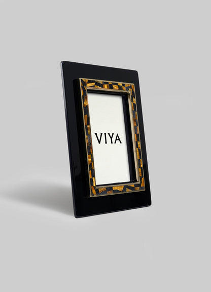The Plaza Photo Frame by VIYA features a glossy black rectangular outer border and a tortoiseshell-patterned inner border, inspired by Bombay Art Deco cinema halls, with VIYA displayed on a plain white background.
