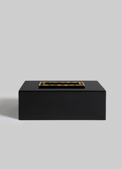 The VIYA Plaza Tissue Box, a sleek rectangular black box with a gold and black Art Deco handle on the lid, set against a plain light gray background, channels the glamour of old Bombay cinema halls.
