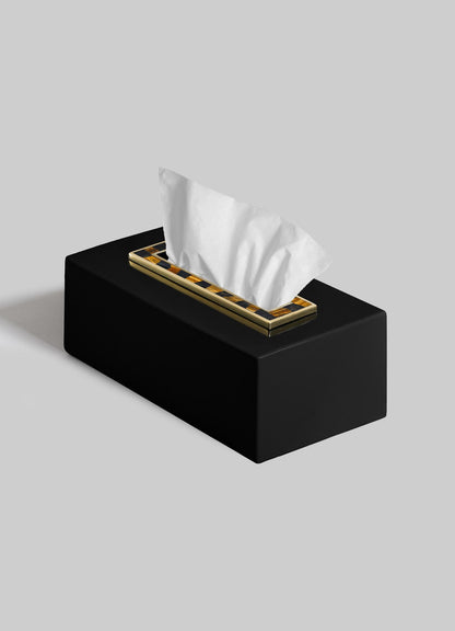The VIYA Plaza Tissue Box features a black rectangular design with Art Deco-inspired metallic gold trim, holding a white tissue partially pulled out, set against a plain gray background.