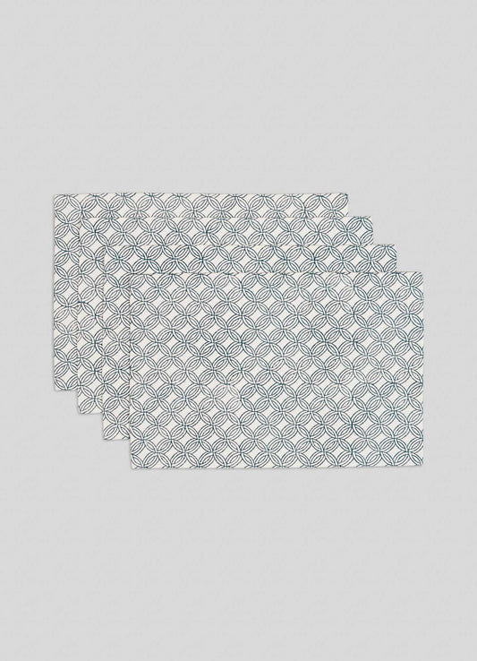 The Viya Paigah Navy Placemats - Set of 4 feature a repeating pattern inspired by Hyderabad’s Indo-Islamic jaalis, with overlapping navy and green circles on white, stacked slightly offset.