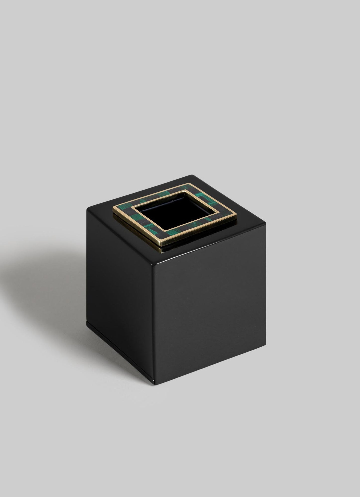 The VIYA Rivoli Cube Tissue Box is a glossy black square with a top opening, framed by gold and green Art Deco accents inspired by Bombay cinema halls, set against a light gray background.