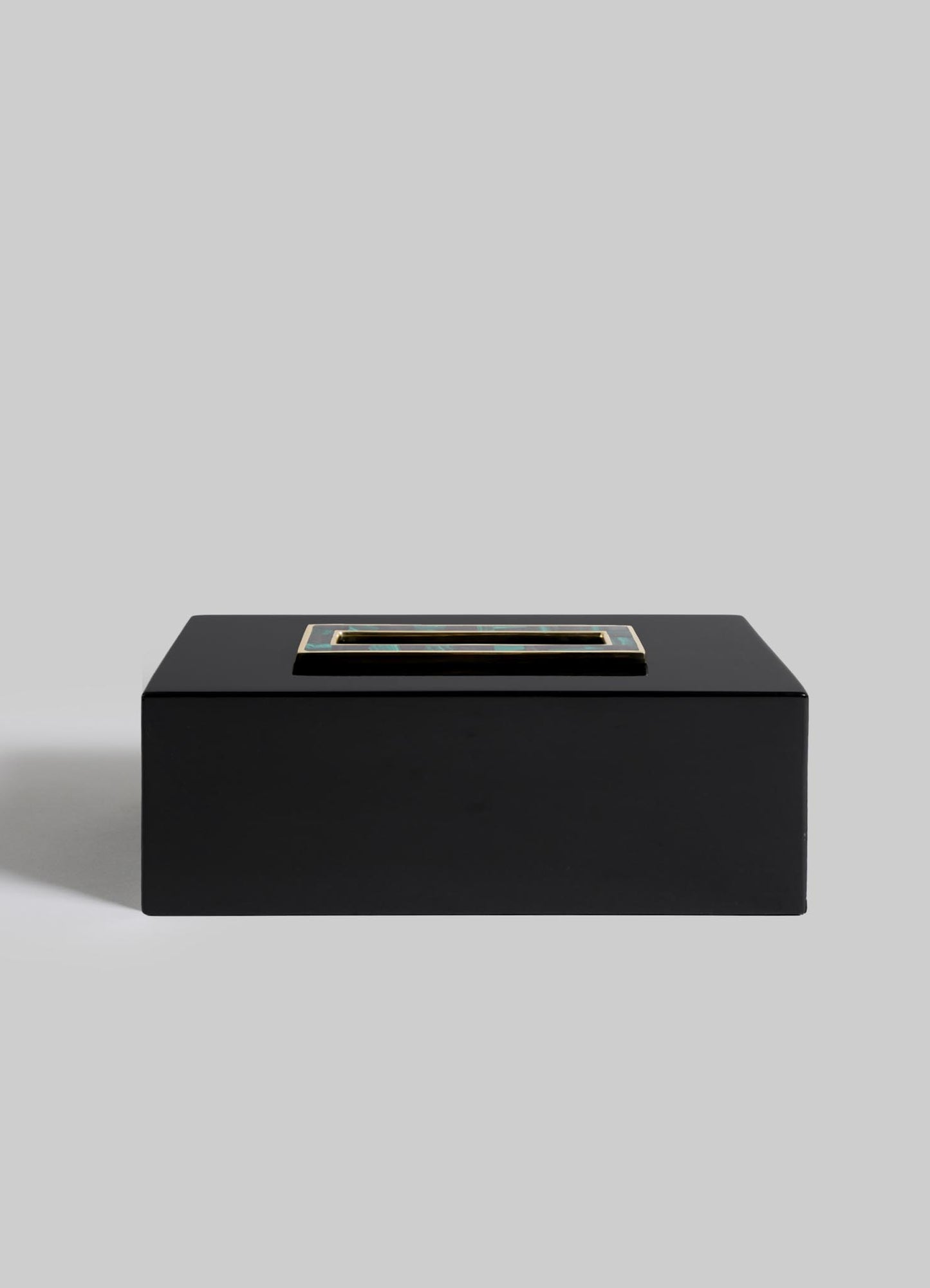 The VIYA Rivoli Tissue Box is a rectangular black box featuring a metallic-edged opening and sleek Art Deco lines, reminiscent of old Bombay cinema halls, displayed against a plain light gray background.