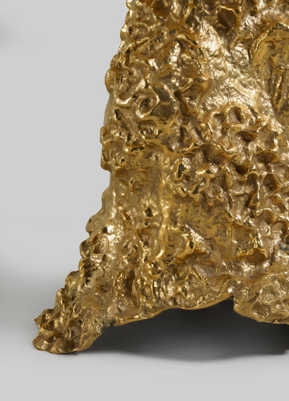 Close-up of VIYA’s Red Earth Table Lamp in gold, featuring a textured, sculptural surface that recalls molten metal or organic forms. Set against a plain light gray background.