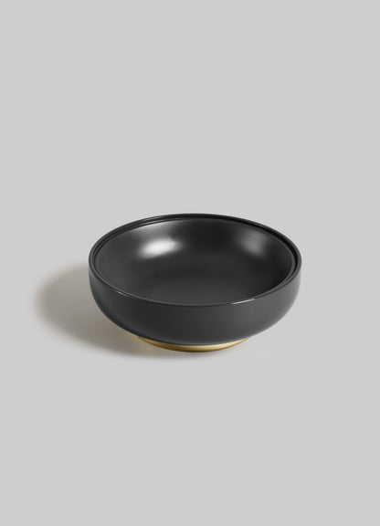 The Saffron Black Trinket Box Large by VIYA features a round, glossy black ceramic design with a matte gold base, displayed on a light gray background—blending modern elegance with inspiration from ancient Indian medicine.