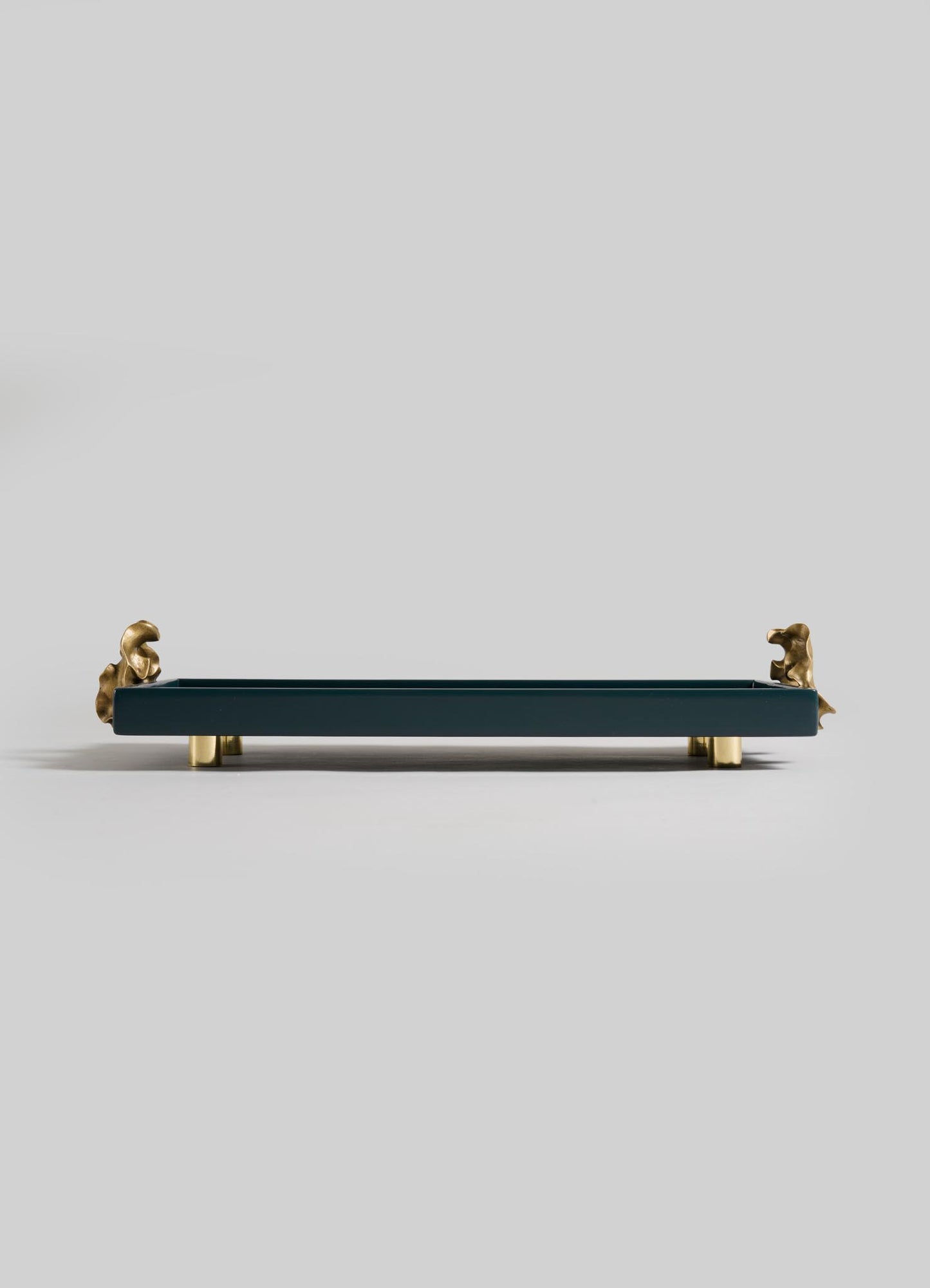The VIYA Saffron Dark Blue Vanity Tray features gold legs and gold decorative animal figures on each end, evoking the elegance of ancient Indian medicine, and is showcased against a plain light gray background.