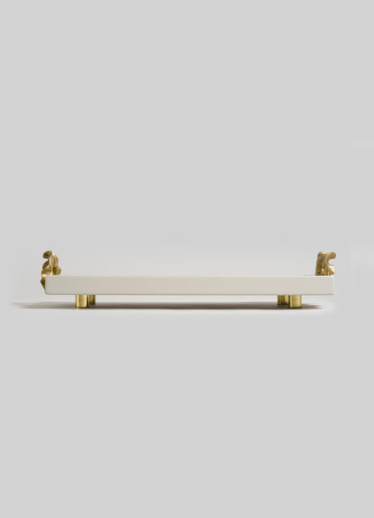 The Saffron Ecru Vanity Tray by VIYA is a rectangular white tray with gold animal-shaped handles and four small round gold legs, evoking contemporary bronzed decor, shown on a plain light gray background.