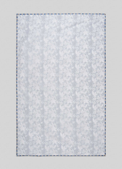 The Viya Spring Bouquet Blue Single Dohar features a subtle floral pattern inspired by Indian gardens, finished with a blue-and-white border, and is displayed flat against a light gray background.