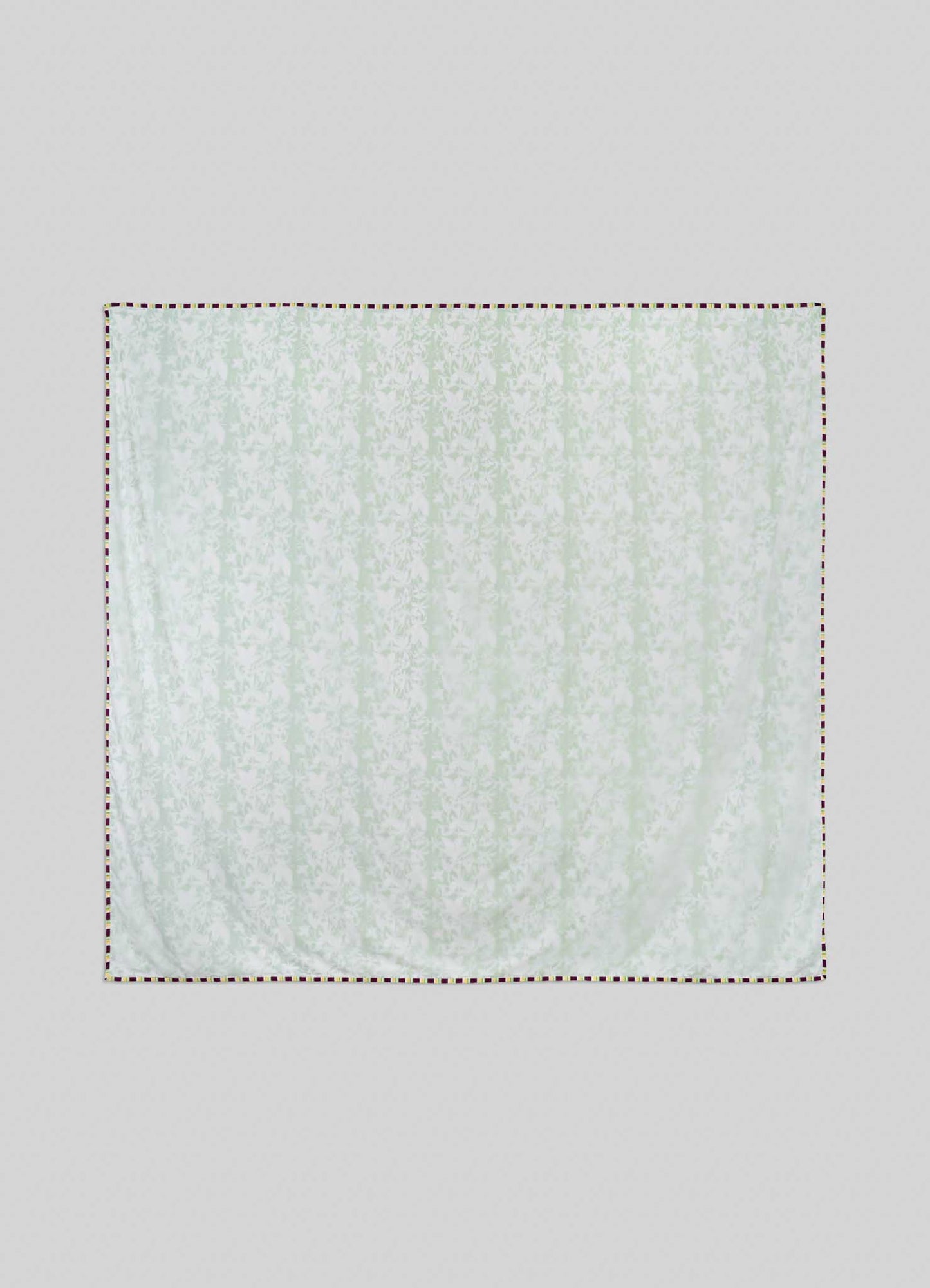 The Viya Spring Bouquet Green King Size Dohar, featuring a subtle floral pattern inspired by Indian gardens, hangs against a light gray background with its edges outlined by a dashed line.
