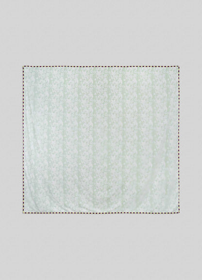 The Viya Spring Bouquet Green King Size Dohar, featuring a subtle floral pattern inspired by Indian gardens, hangs against a light gray background with its edges outlined by a dashed line.