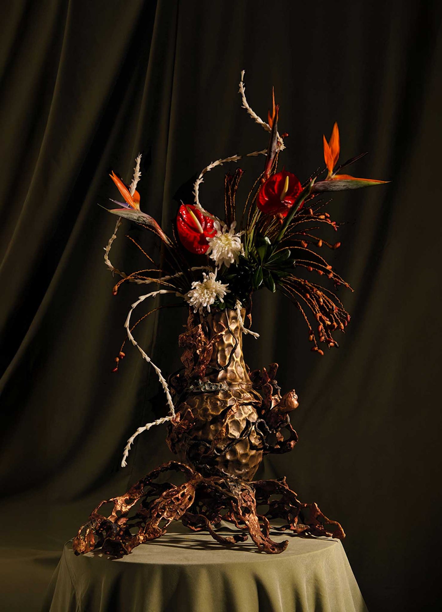 The VIYA Spring In Kashmir Vase Large features a dramatic floral arrangement in a pinecone-textured vase with sculptural brown metal roots, blooming tulips, and exotic flowers, perfect for adding Kashmiri elegance to any room.