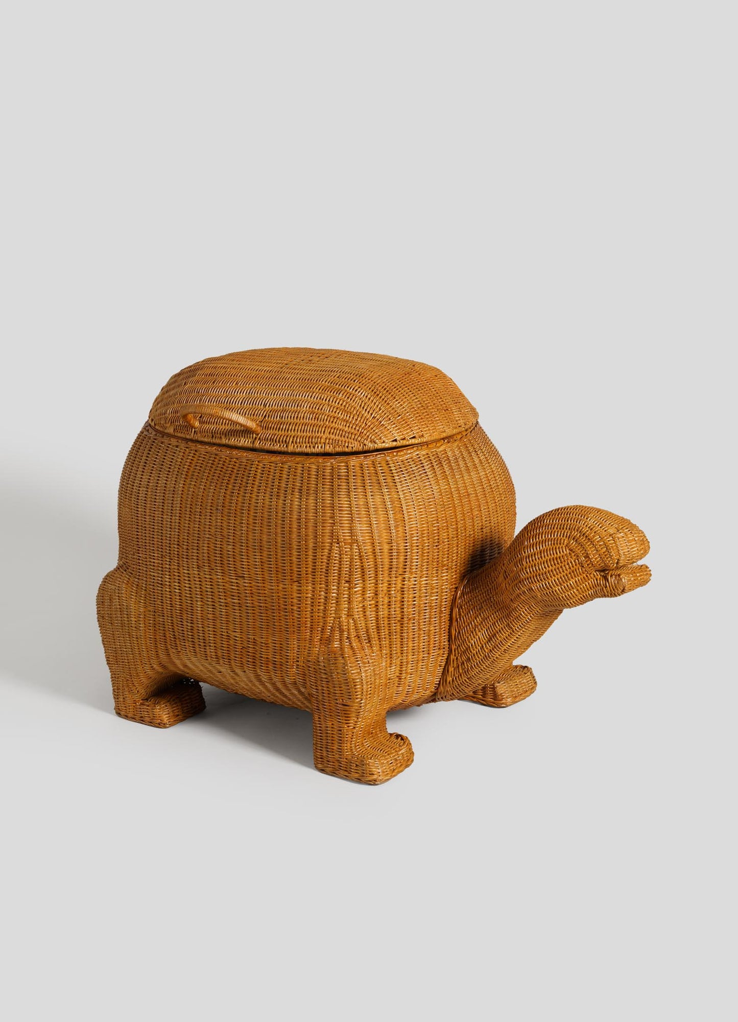 The VIYA Tortoise Laundry Basket is a woven rattan storage basket shaped like a tortoise, with cane weaving, four legs, a head, and a removable lid forming the shell.