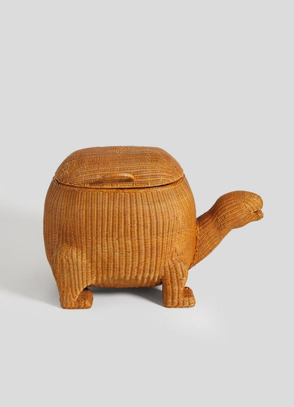 The VIYA Tortoise Laundry Basket features intricate cane weaving on a turtle-shaped rattan body with four legs, a long neck, and a shell lid, displayed against a plain light background.